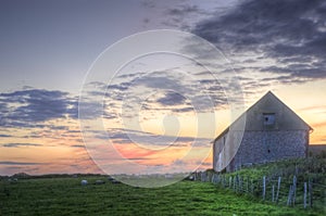 Old barn in landscape at sunset