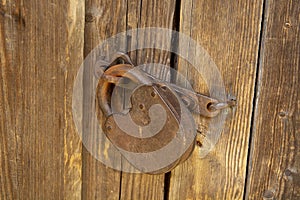 an old barn lock on a wooden door. Rusty lock