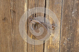 an old barn lock on a wooden door. Rusty lock