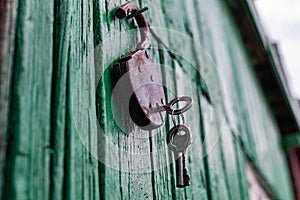 Old barn locks with keys hang on the painted green wood wall.
