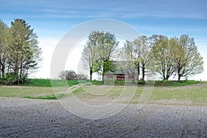 Old barn in rural Michigan with long drive way and fresh plowed field