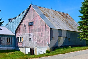 An old barn in rural NH with a facade in weathered red and blue paint