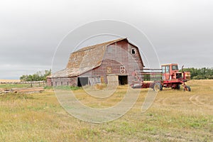 Old barn and swather in a farmyard