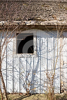 Old barn wall with newer white siding and original wood shingles