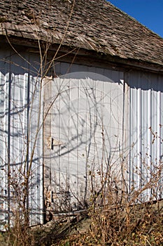 Old barn wall with newer white siding and original wood shingles