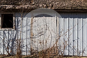 Old barn wall with newer white siding and original wood shingles