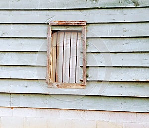 Old barn window with bars and borded metal bo