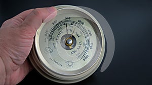 Old barometer in hand on black background