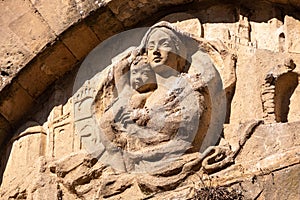 An old baroque engraved sculpture of Mary and Jesus over an entrance to the Cappella della Croce di Giorno in Volterra photo