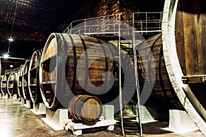 Old barrels in the wine cellar. Wine cellar with old oak barrels, production of fortified dry or semi-sweet wine.