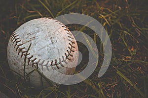 Old baseball ball on the grass