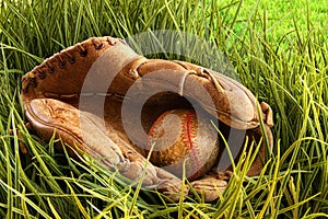 Old baseball glove with ball in the grass