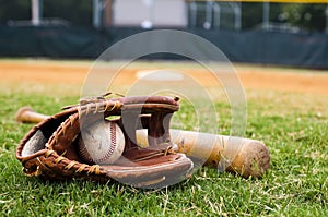 Old Baseball, Glove, and Bat on Field photo