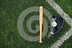 Old baseball glove and bat on field