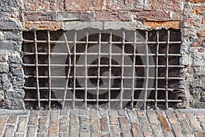 Old basement window with a lattice, covered with cardboard and boards