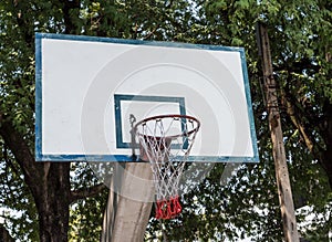 Old basketball hoop on the concrete pole.