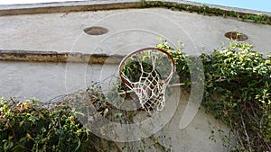 An old basketball hoop on the wall of an old country house.