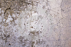 Old, battered, damaged white concrete wall with cracks and dark paint and mildew stains. rough surface texture