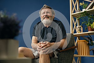Old bearded man suffering from knee pain