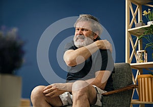 Old bearded man suffering from pain photo