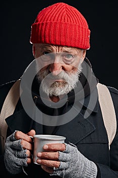 Bez domova muž snaží na teplý sám džbánok z horúci piť 