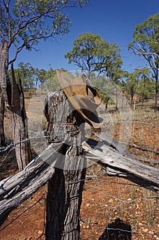 Old beaten up Australian bushmans` hat on fence.