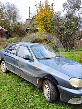 An old beaten-up car in a small Russian village.