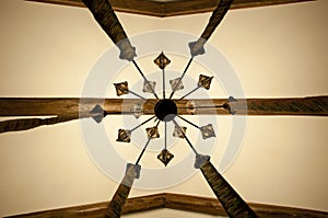 Old but beautiful. Classic overhead interior surface. Old ceiling. Wood beam ceiling. Decorative lamp hanging from ceiling.