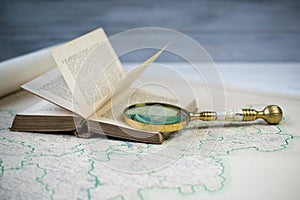 Old beautiful golden magnify glass on ancient book and old map