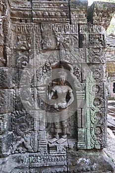Murals and sculptures of vishnu, shiva, hindu god symbol, face in ancient temple ruins of angkor wat, cambodia
