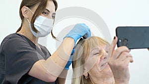 An old beautiful woman at an appointment with a trichologist. Hair care and treatment in old age