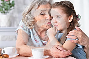 Old woman with a young girl drinking tea