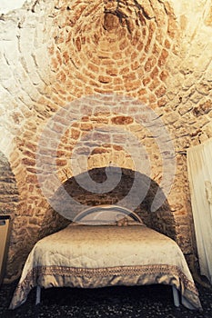 Old bedroom with double bed in a Trullo in Italy, typical roof construction