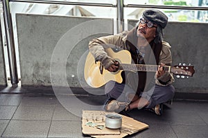 Old beggar play guitar  for money donation
