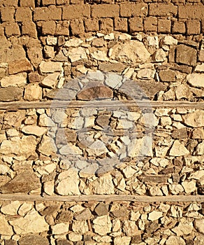 Old beige stone wall background texture, close up. Ancient wall made out of stones and bricks. Textures and background