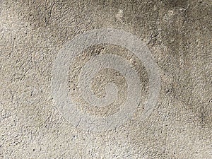 Old beige wall with soft abstract shadows on it. Cement surface close-up. Grunge concrete texture, minimal background.