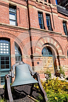 Old Bell by Brick Building