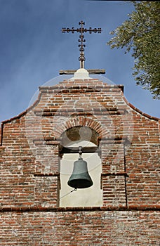 An old bell tower with a cross at the Mission San Antonio de Padua, Jolon CA.
