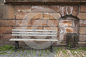 The old bench of the castle wall in the old town of Germany with trashbin