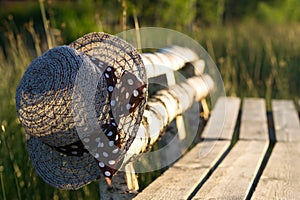 On an old bench weighs a straw hat against a background of green grass