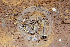 Old rusty nails and screws on rusty background and texture
