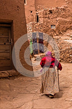Old berber woman at narrow street of Ait Ben Haddou village, UNESCO world heritage site in Morocco