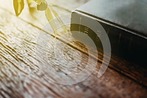 The old bible on wood desk with sunlight.