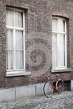 Old bicycle against brick wall