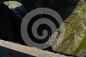 Old bicycle on the bottom of dried river or channel in the dirt silt in Europe. Concept of pollution and lack of water