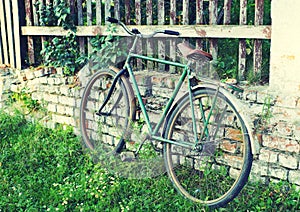 Old bicycle about a brick wall in a summer sunny day