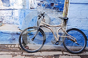 Bicycle leaning against an old blue painted wall