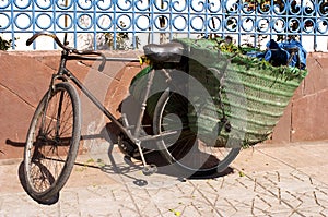Old bicycle leaning against wall with panniers on the back