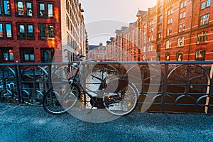 Old bicycle parked against iron hand railing on bridge in Hamburg warehouse district