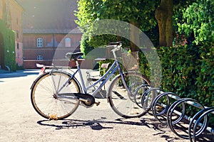 Old bicycle in the parking lot, in a beautiful garden. Summer sunny day. Transpot. Bicycles.